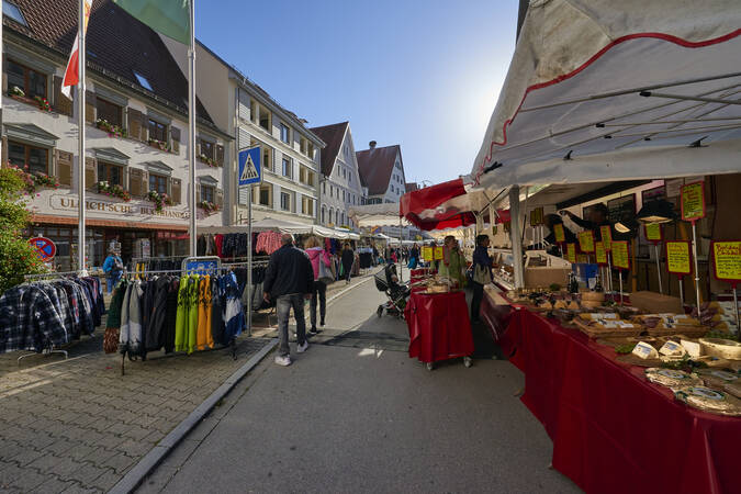 Unterschiedliche Stände mit Lebensmitteln und Kleidung auf dem Gallusmarkt 