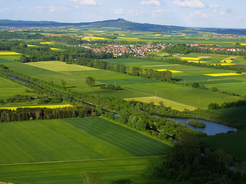 Luftaufnahme vom Bussen. Im Vordergrund sind grüne Felder zu sehen.