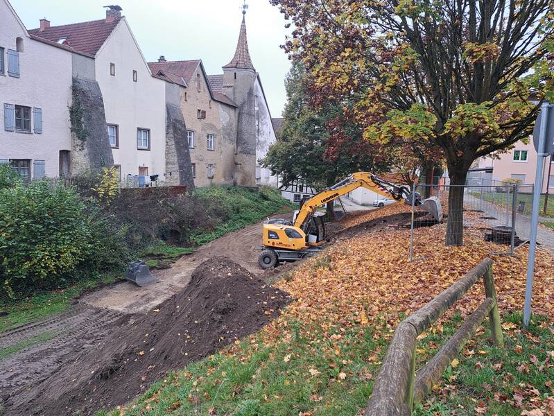 Der Bagger beginnt im Stadtgraben mit den Aushubarbeiten