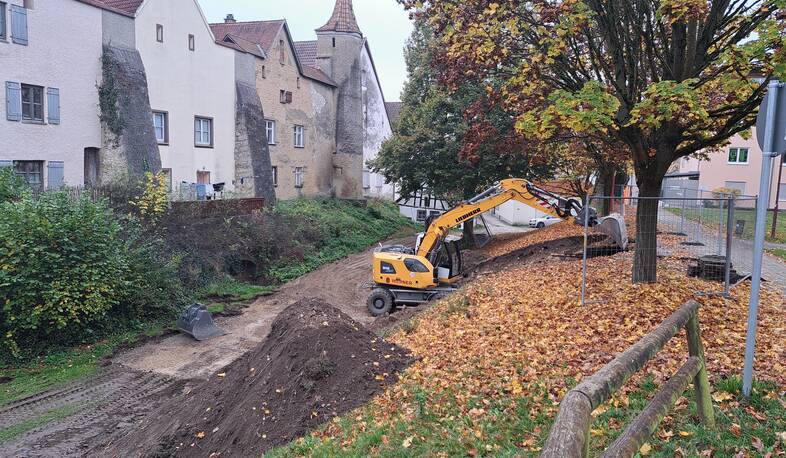 Der Bagger beginnt im Stadtgraben mit den Aushubarbeiten