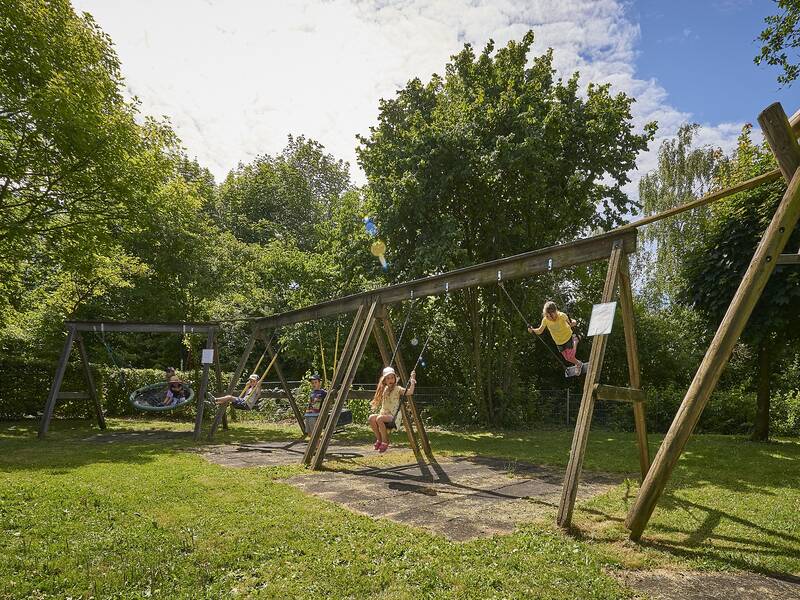 Spielwiese mit überschattetem Sandkasten der Kindertageseinrichtung Regenbogen