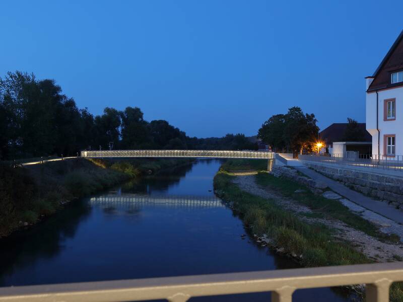 Inselbrücke mit Spiegelung in der Donau abends